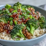 A serving of Sweet and Spicy Turkey Broccoli Bowls garnished with fresh green onion and sesame seeds.