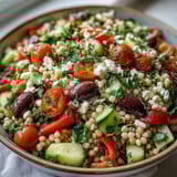 Mediterranean Pearl Couscous tossed with crunchy cucumbers, sweet bell peppers, and briny kalamata olives.