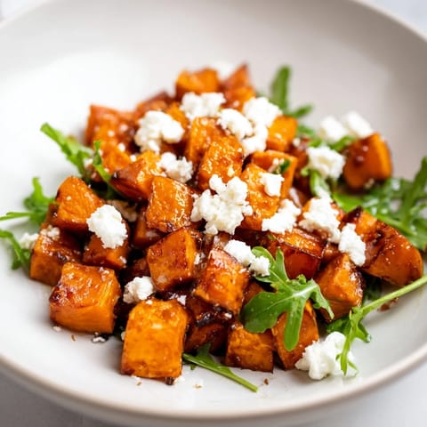 This vibrant Roasted Sweet Potato Salad is topped with creamy feta, red onion, and crunchy pepitas for texture.