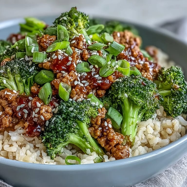 A serving of Sweet and Spicy Turkey Broccoli Bowls garnished with fresh green onion and sesame seeds.