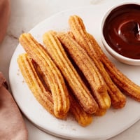 Golden, crispy churros dusted with cinnamon sugar, ready to be dipped into rich chocolate.