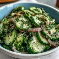 A vibrant cucumber radish salad with dill vinaigrette, showcasing crisp cucumbers and peppery radishes tossed in a bright, herbaceous dressing.