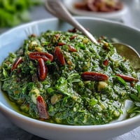 Bright green dandelion pesto with garlic and toasted pine nuts, perfect for pasta or sandwiches.